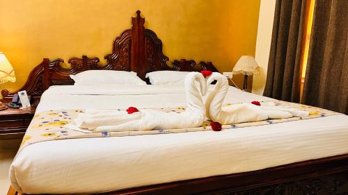 a bed with two swans made out of towels at Hotel Master Paradise, Pushkar, Rajasthan , INDIA in Pushkar