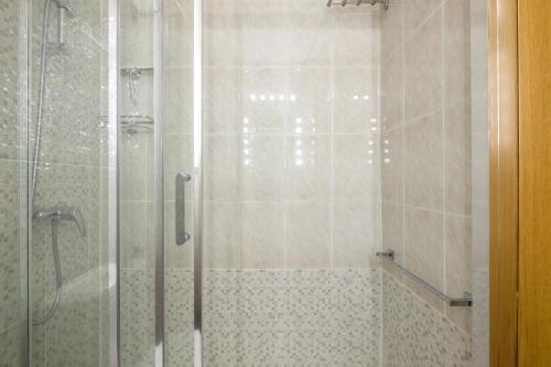 een douche met een glazen deur in een badkamer bij My City Home - Acogedor apartamento en Aravaca in Madrid