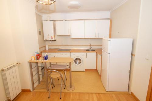 a small kitchen with a table and a refrigerator at MAGIC I a 1 minuto de la Catedral y Plaza Mayor in León