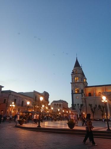 a building with a clock tower in a city at night at Narciso boutique apartment in Acireale