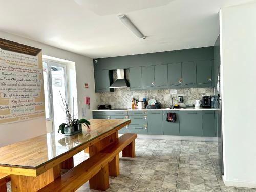 a kitchen with green cabinets and a wooden table at City's Hostel Ponta Delgada in Ponta Delgada