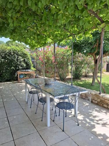 une table et des chaises assises sur une terrasse dans l'établissement Villa Leis Moelos, à Beaumes-de-Venise
