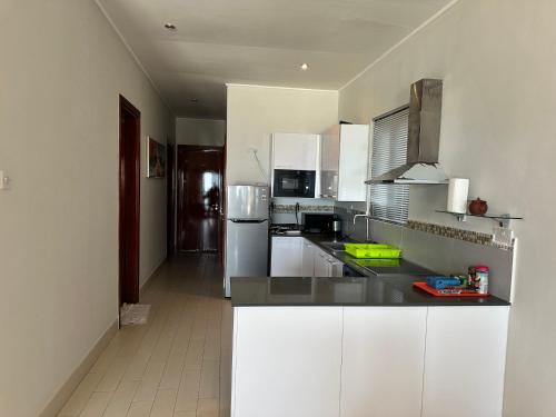 a kitchen with white cabinets and stainless steel appliances at Townhouse T1, Relax Waterfront in Bijilo