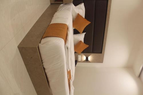 a bed in a room with white sheets and pillows at Hotel Metro Inn in Mumbai
