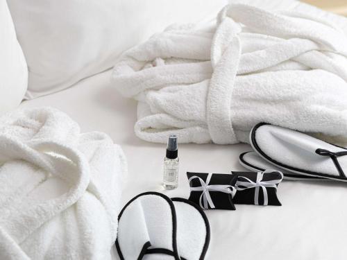 a pair of glasses and towels and a bottle of wine at Mercure London Earls Court in London