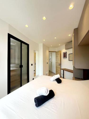 une chambre avec un grand lit blanc avec des serviettes dessus dans l'établissement Appartement 4 pièces luxueux, à Cannes