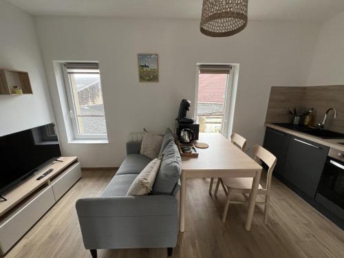 un salon avec un canapé et une table en bois dans l'établissement Evasion Maritime - Appart 2p Montreuil-sur-Mer, à Écuires