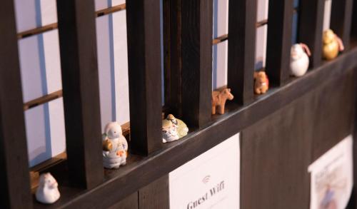 a row of toy chickens sitting on a shelf at つなぐ古民家 in Kaizuka