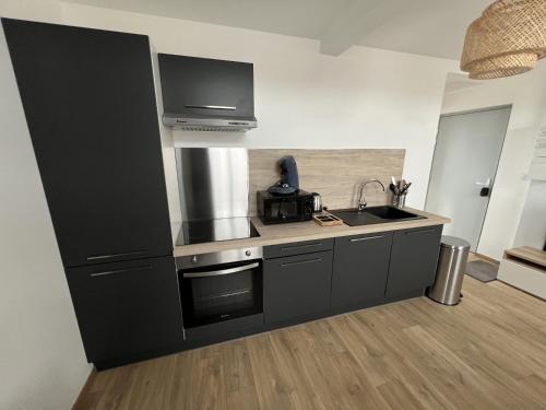 une cuisine avec un évier et un plan de travail dans l'établissement Le Refuge Littoral - Appart 2p Montreuil-sur-Mer, à Écuires
