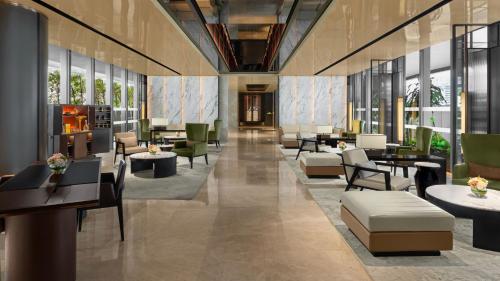 a lobby with tables and chairs and windows at InterContinental Singapore Robertson Quay by IHG in Singapore