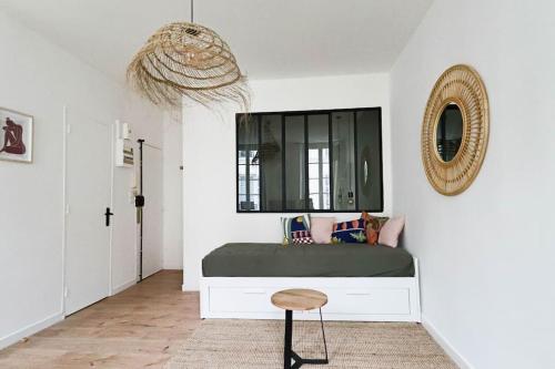 - une chambre avec un lit doté d'un miroir et d'un tabouret dans l'établissement CharmantT2 dans le quartier branché du Camas, à Marseille