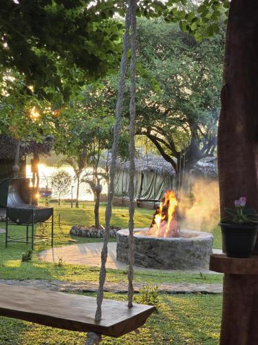 a fire pit in a park with a swing at Nagara Lake Glamping Resort in Hambantota