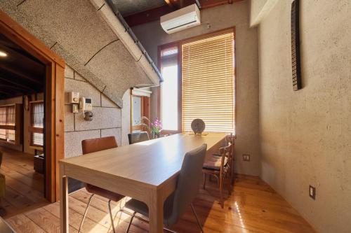 a dining room with a wooden table and chairs at 博世庵 in Nishikatsuracho
