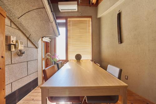 a conference room with a wooden table and chairs at 博世庵 in Nishikatsuracho