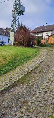 a cobblestone street with a tower in the background at Ferienwohnungen Waldsicht und Dorfsicht in Winkel