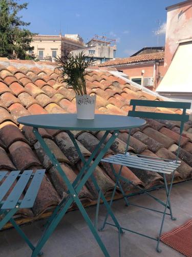 a blue table and a chair and a potted plant at Narciso boutique apartment in Acireale