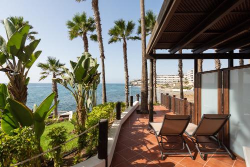 a patio with palm trees and the ocean at Suite Altamar - by Gestión Vacacional Canarias in Playa del Aguila