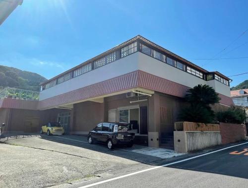 a car parked in front of a building at 南熱海長浜公園近くバーベキュー可能露天風呂付ゲストハウス in Taga
