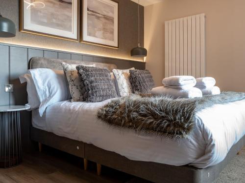 a bedroom with a bed with white sheets and pillows at Arran Shores 7 in Lamlash