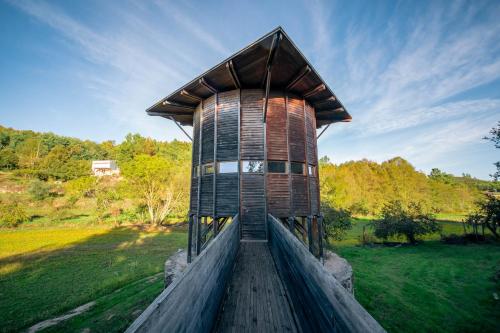 a wooden tower in a field with trees in the background at Casa do Marujo e Casa do Mirone in Fornos de Algodres