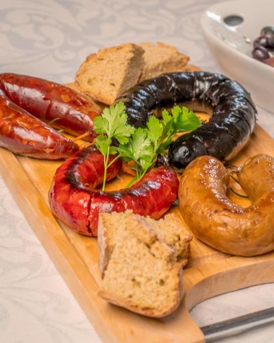 a plate of sausage and other foods on a cutting board at Casa do Marujo e Casa do Mirone in Fornos de Algodres