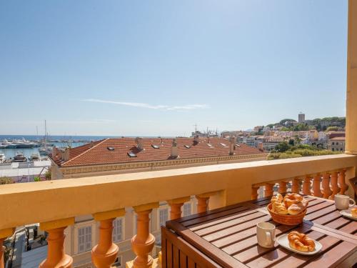 - un balcon avec une table et de la nourriture dans l'établissement LE VOILIER avec terrasse panoramique vue mer et port, proche du Palais, Croisette et plages, à Cannes