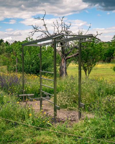 a metal structure in a field with a tree at Casa do Marujo e Casa do Mirone in Fornos de Algodres