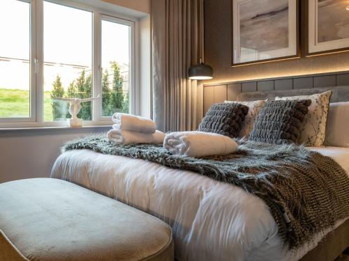 1 dormitorio con 1 cama con manta y ventanas en Converted Church, Lamlash Shorefront, Arran Shores Garden Terrace Apartment 6, en Lamlash