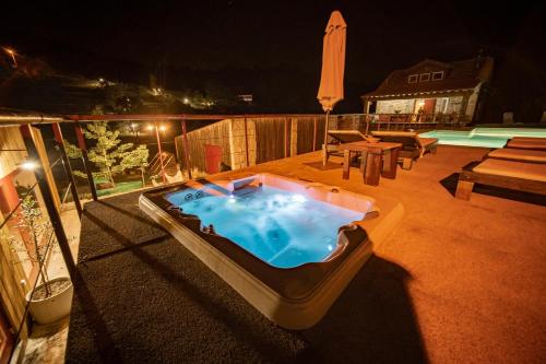 a hot tub sitting on a patio at night at Casa do Marujo e Casa do Mirone in Fornos de Algodres