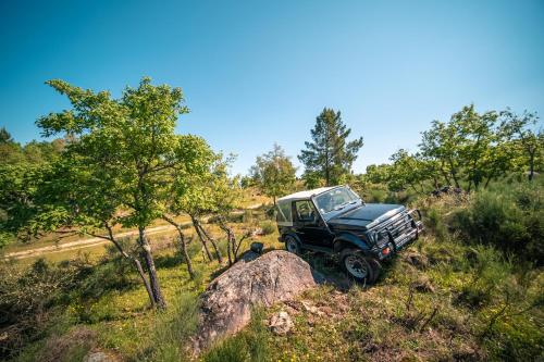 a jeep parked on a hill next to a rock at Casa do Marujo e Casa do Mirone in Fornos de Algodres