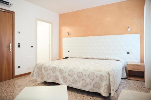 a bedroom with a large bed with a white bedspread at Hotel Roma in Cittadella
