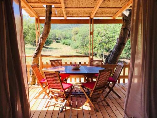 un patio avec une table et des chaises sur une terrasse dans l'établissement Chalet 4 étoiles - efaaba, à Roquebrune-sur Argens