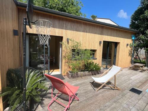 ein Basketballkorb und zwei Stühle auf einer Terrasse in der Unterkunft La petite Dépendance in Le Bouscat