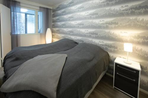 a bedroom with a bed and a wall with clouds at Beautiful and peaceful home near Levi center in Kittilä