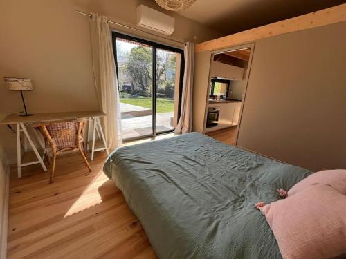 une chambre avec un lit et une grande fenêtre dans l'établissement La petite Dépendance, à Le Bouscat