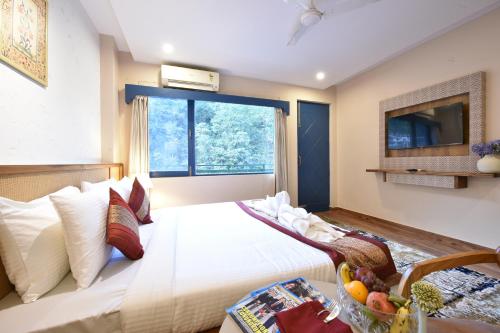 a bedroom with a white bed with a window at Tiaraa Lite A Ganges Retreat in Shivpuri