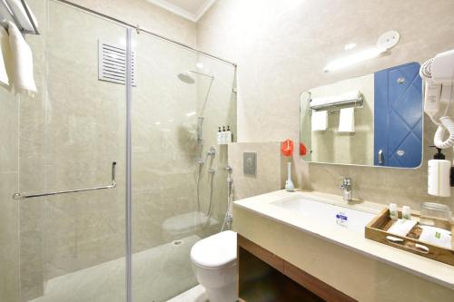a bathroom with a shower and a sink and a toilet at Tiaraa Lite A Ganges Retreat in Shivpuri