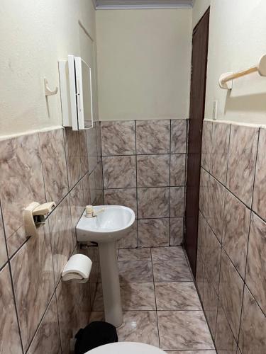 a bathroom with a sink and a toilet at Suítes São Judas in Pirenópolis