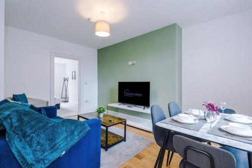 a living room with a blue couch and a table at Sleeps 6, Stylish Apartment, Perfect For Groups, Long Term Disc in Otley