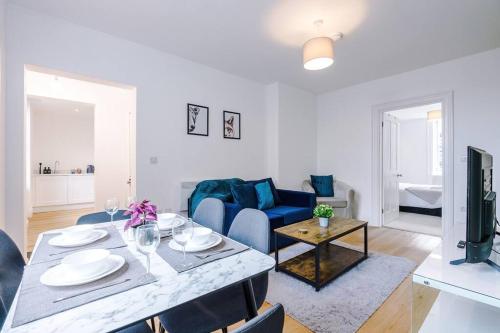 a living room with a table and a blue couch at Sleeps 6, Stylish Apartment, Perfect For Groups, Long Term Disc in Otley