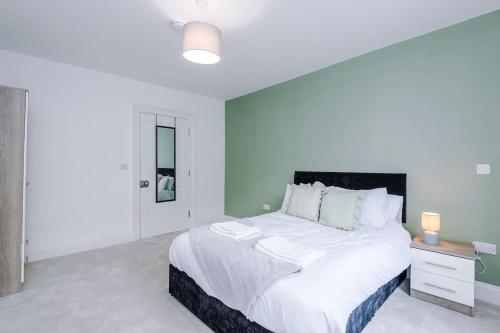 a white bedroom with a large bed and a desk at Sleeps 6, Stylish Apartment, Perfect For Groups, Long Term Disc in Otley