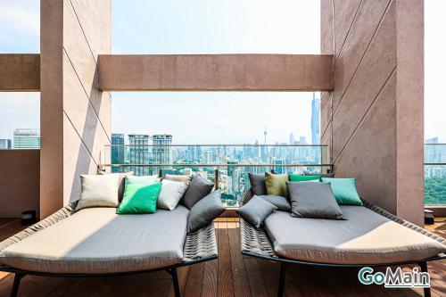 a balcony with two beds with a view of the city at 24h Check in & SkyPool- KL Sentral Suite Riveria City Near KL Sentral KL KLCC in Kuala Lumpur