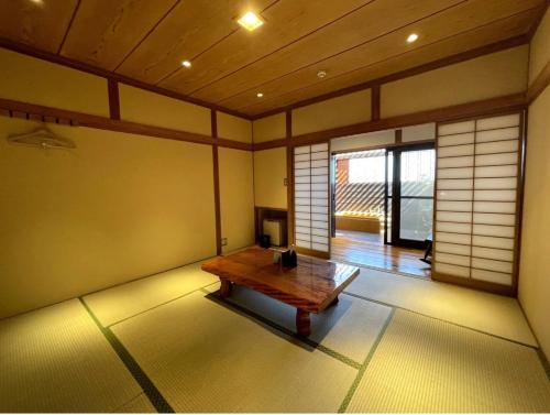 a room with a wooden table in the corner of a room at 南熱海長浜公園近くバーベキュー可能露天風呂付ゲストハウス in Taga