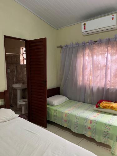 a bedroom with two twin beds and a window at Suítes São Judas in Pirenópolis