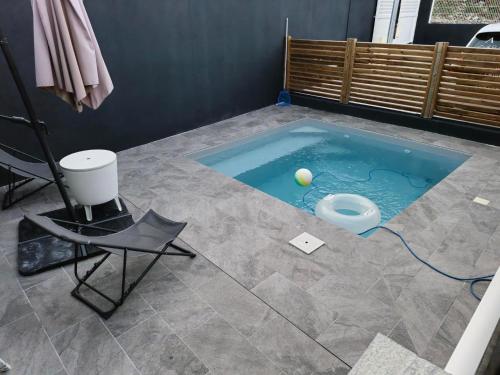 a swimming pool with a tennis ball in the middle at Chambres d'hôtes dans Villa à Chateauboeuf in Fort-de-France