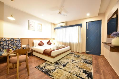 a bedroom with a bed and a table and a chair at Tiaraa Lite A Ganges Retreat in Shivpuri