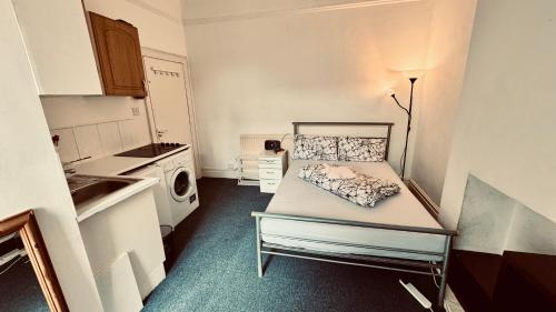 a small kitchen with a bed in a room at the quite one in London