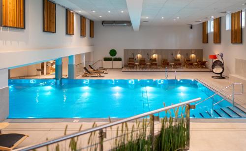 a large swimming pool in a large room with a largeospital building at Kongresshotel Potsdam am Templiner See in Potsdam
