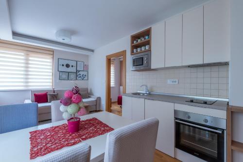 eine Küche und ein Wohnzimmer mit Tisch und Stühlen in der Unterkunft Konačište Egoiste - Centar in Zlatibor