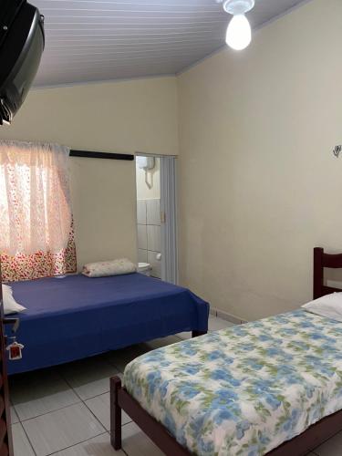 a bedroom with two beds and a blue bedspread at Suítes São Judas in Pirenópolis